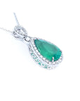 Emerald green teardrop pendant with white gold chain on a right side position topside and gallery visibles.