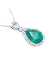 Pear-cut Colombian emerald pendant with diamond halo, set in 18K white gold.