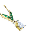 Natural pear cut diamond with emeralds necklace dangling from a V style center piece with natural round cut emeralds
