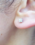 A woman's ear dressing a natural diamond stud earring screw back.
