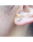 A woman's ear dressing a natural diamond stud earring screw back.
