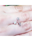 0.46 ct natural diamond stud earrings with screw backs, set in 14K white gold on a hand.