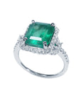 A natural emerald engagement ring with an emerald-cut encircled by a halo diamond, on top and side view position.
