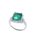 Emerald-cut natural Colombian emerald ring with diamond halo and band in 14k white gold.