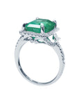 The emerald and halo diamond engagement ring in this image displays its top and half side profile.