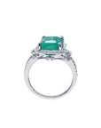 Emerald-cut natural Colombian emerald ring with diamond halo and 14k white gold band.