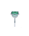 Emerald-cut natural emerald ring with diamond halo and diamond-set 14k white gold band.