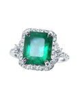 This emerald-cut natural colombian emerald ring for women with a halo diamond is crafted in 14k white gold.
