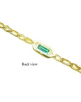The back side view of a gold bracelet with a rectangular emerald on a white background