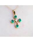 18K yellow gold cross pendant with four round Colombian emeralds and a central diamond.