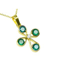 A colombian emerald cross pendant necklace four leaves handcrafted in 18k yellow gold displaying top and side profile.