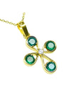 A colombian emerald cross pendant necklace four leaves handcrafted in 18k yellow gold displaying top and side profile.