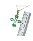 18K yellow gold cross pendant with four round natural Colombian emeralds and a central diamond.