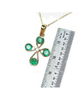 18K yellow gold cross pendant with four round natural Colombian emeralds and a central diamond.