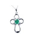 A 14k white gold emerald cross pendant necklace, displaying the topside view.