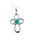 A 14k white gold emerald cross pendant necklace, displaying the topside view.