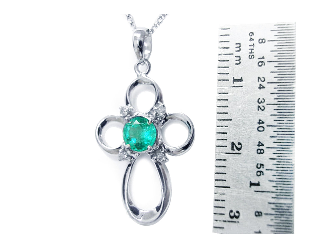 14k white gold pendant with a center natural emerald next to a ruler for scale on a white background.