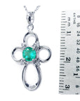 14k white gold pendant with a center natural emerald next to a ruler for scale on a white background.