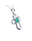 14K white gold cross pendant with a round natural Colombian emerald and diamond accents.