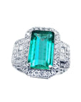 A GIA certified F1 natural Colombian emerald ring rectangular emerald-cut surrounded by a halo diamond in 18k white gold.