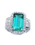 A GIA certified F1 natural Colombian emerald ring rectangular emerald-cut surrounded by a halo diamond in 18k white gold.