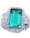 Top side view with shoulder profile of a natural Colombian emerald ring on a white background.