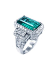 18K white gold ring with a rectangular F1 Colombian emerald, haloed by diamonds, and baguette side stones.