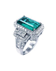 18K white gold ring with a rectangular F1 Colombian emerald, haloed by diamonds, and baguette side stones.