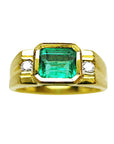 Gold ring for men with a natural emerald and two side diamonds on a topside view position/
