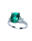1.90 carat cushion cut emerald ring with trapezoid side diamonds in 18K white gold.