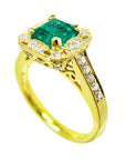 Gold ring with a natural emerald and diamond accents on a white background.