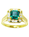 A 14k yellow gold emerald rings with accent diamonds around, on a topside view.