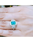 2.47 ct GIA certified F1 emerald engagement ring with diamond halo and baguette side diamonds in 18K white gold.