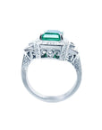 18K white gold engagement ring with a vibrant emerald, diamond halo, and baguette side diamonds.