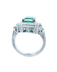 18K white gold engagement ring with a vibrant emerald, diamond halo, and baguette side diamonds.