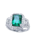 This natural colombian emerald engagement ring is adorned with a halo of natural diamonds and made of 18k white gold.
