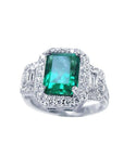This natural colombian emerald engagement ring is adorned with a halo of natural diamonds and made of 18k white gold.