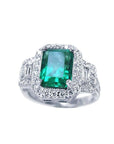 This natural colombian emerald engagement ring is adorned with a halo of natural diamonds and made of 18k white gold.