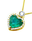 Gold necklace with a heart-shaped emerald and diamond pendant on a left side profile view.