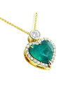 Heart-shaped natural Colombian emerald pendant with gold border and small halo diamond, topside view.