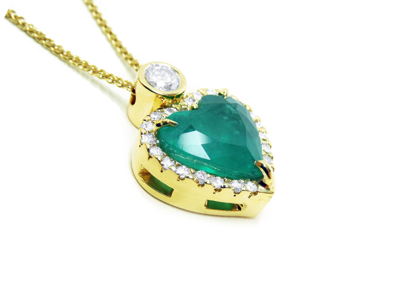 Gold necklace with a heart-shaped emerald pendant on a side profile gallery view.