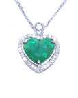 Heart-shaped emerald pendant on a topside view front position, halo diamond visible.