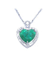 Heart-shaped emerald pendant on a topside view front position, halo diamond visible.