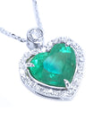 Heart-shaped emerald pendant with diamond accents on a toside view position