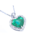 Heart-shaped emerald pendant with diamond accents on a toside view position