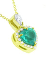 Gold pendant with a heart shaped emerald and diamonds on a white background.