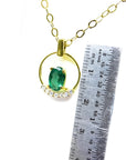 14k yellow gold necklace with oval 0.85 ct Colombian emerald and diamond accents, shown with ruler for scale.