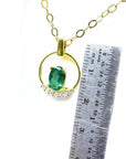 14k yellow gold necklace with oval 0.85 ct Colombian emerald and diamond accents, shown with ruler for scale.