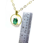 14k yellow gold necklace with oval 0.85 ct Colombian emerald and diamond accents, shown with ruler for scale.