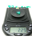 2.25 ct. natural pear-cut Muzo mine Colombian emerald on a digital scale, displaying vivid bluish-green color.
